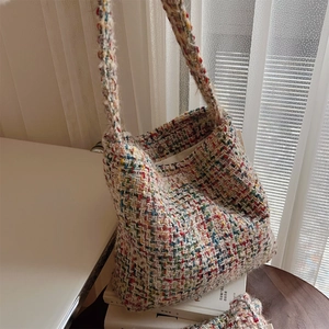 Detail of colorful tweed knit texture and woven shoulder strap of the woven tote bag