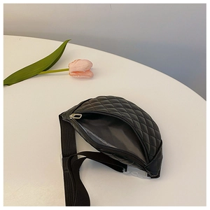 Close-up of black quilted leather waist bag for kids with silver zipper and nylon strap