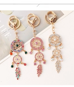 Detailed view of three dreamcatcher keychains with sparkling crystals and feathers