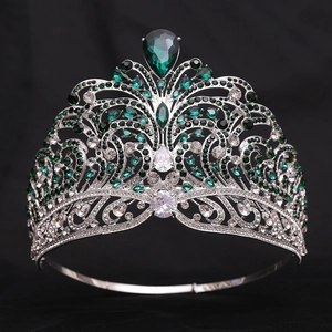 Macro detail of silver crown with emerald teardrop crystals and baroque rhinestones