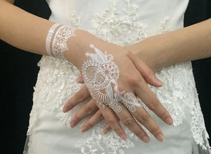 Detailed close-up of white lace temporary tattoo sticker on wrist and hand