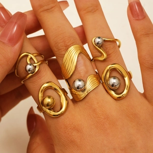 Close-up of two-tone gold and silver irregular steel ball rings worn on hand