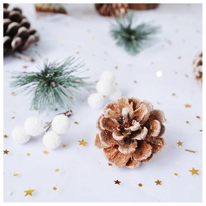 Close-up of frosted pine cones and white berries with artificial pine needles