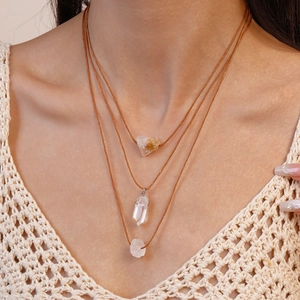 Three-layer bohemian necklace featuring irregular natural crystal pendants on brown cord