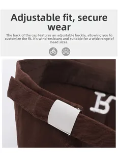 Detail of adjustable metal buckle on dark brown cotton baseball cap for a secure fit