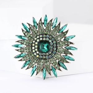 Detail of sunflower brooch with emerald green crystals and vintage gold alloy plating