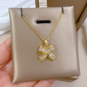 Close-up of golden titanium necklace featuring a butterfly pendant with zircon crystals