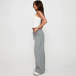 Détail du pantalon large gris montrant la taille à cordon et la texture en coton doux