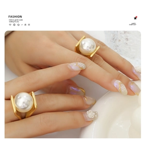 Close-up of a bold gold-plated wide ring with a large white pearl on a model hand