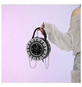Detail of round handbag with creative piano key pattern and clock face design