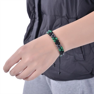 Detail of double-layer hand-woven bracelet with green malachite and black obsidian beads