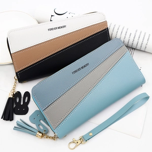 Detail of color-block zipper wallet featuring fringe tassel and rabbit charm decoration