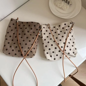 Flat lay view of vintage polka dot corduroy mini crossbody bags in grey and cream colors