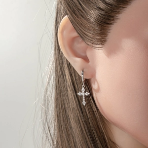 Silver cross huggie hoop earrings with micro-set zircons on a model for a stylish look