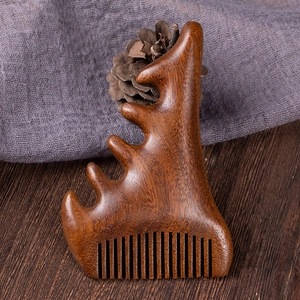 Macro shot of red sandalwood meridian massage comb with wavy handle on dark wood