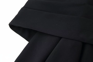 Macro shot of black twill fabric detailing the cross-over design and fine stitching
