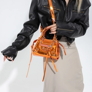 Orange glossy patent leather tote with rivets and tassel, vintage motorcycle style bag