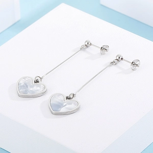 Detailed view of silver heart drop earrings with shimmering mother of pearl inlay