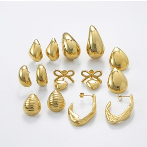 Multiple pairs of gold stainless steel stud earrings including teardrop and heart shapes
