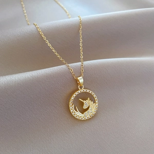 Golden unicorn necklace with cubic zirconia pendant on luxury champagne satin background