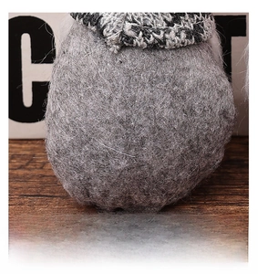 Macro detail of grey felt Christmas gnome back with black and white plaid knit hat
