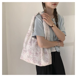 Lace tote bag with pink butterfly embroidery on a shoulder strap shown by a model