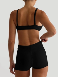 Close-up of black ribbed yoga set showing high-waisted shorts and seamless fabric texture