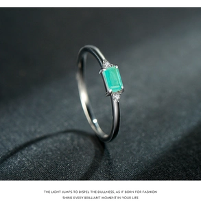 Dettaglio macro di gemma verde taglio smeraldo su anello sottile in argento s925 e diamanti