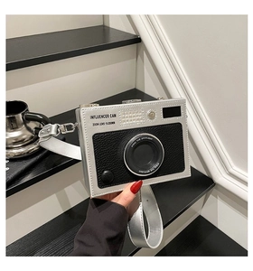 Detail showing the vintage camera-shaped crossbody bag with influencer zoom lens graphics