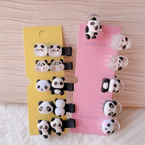 Nahaufnahme süßer Panda-Haarspangen und Krallenclips auf gelben und rosa Karten