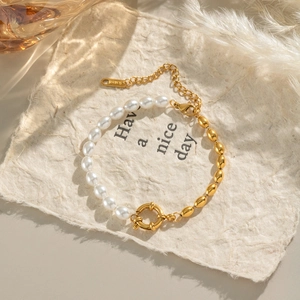 Elegant 18K gold-plated stainless steel bracelet with oval pearls on textured paper