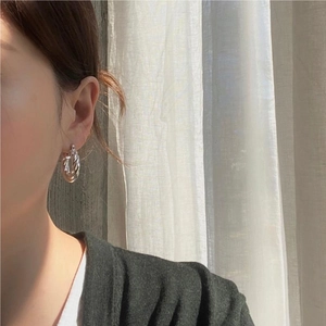 Elegant 925 sterling silver twisted hoop earrings worn by a model in natural light