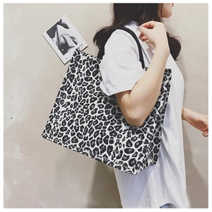 Detail of leopard print canvas tote bag carried by model for casual styling
