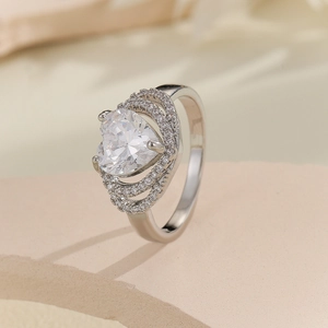 Close-up of silver heart ring with triple-layered zircon halo and crown setting