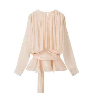 Détail de robe en satin avec texture plissée, liens à la taille et boutons perle aux poignets