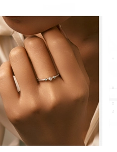 Close-up of S925 sterling silver ring with pavé diamonds and cyan gemstone on finger