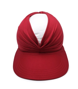 Detail of red fabric visor showing elastic pleated texture and front knot design on a head