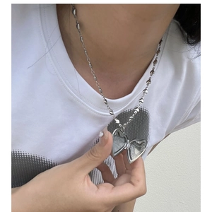 Silver vintage heart locket necklace with unique heart-shaped chain links on person