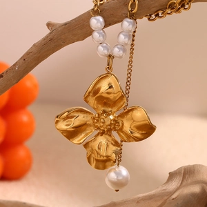 Close-up of 18K gold floral pendant necklace with white pearls on a minimalist chain