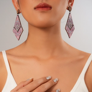 Close-up of model wearing geometric wooden earrings with colorful ethnic patterns