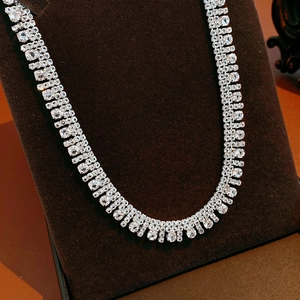 Dettaglio di collana multistrato in argento con zirconi su un supporto in velluto