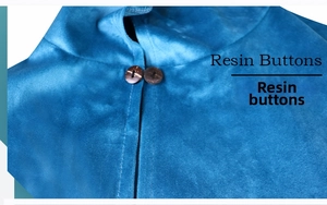 Detailed close-up of dark brown resin buttons on a blue velvet medieval hooded cloak