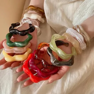Colorful acrylic bangles with irregular wave texture in amber and marble green finishes