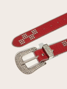 Detail of red punk belt featuring rhinestone buckle and silver metal studs on faux leather