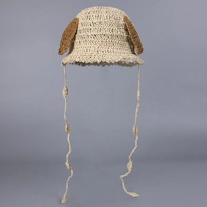 Detailed macro shot of beige hand-crocheted sun hat with cute brown dog ears and chin straps
