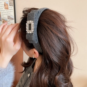 Detailed side view of grey flocked headband with a luxury sparkling crystal buckle decoration