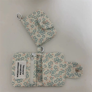 Macro detail of canvas coin purse showing floral print and functional snap closure