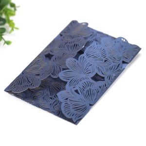 Detail of laser-cut navy blue floral invitation card with intricate hollowed patterns