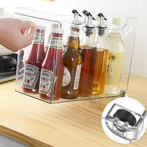Kitchen clear acrylic organizer with handle and wheels on wooden countertop for spices
