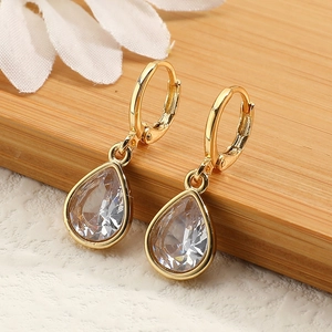 Detailed macro view of pear-shaped drop earrings with gold plating and clear cubic zirconia